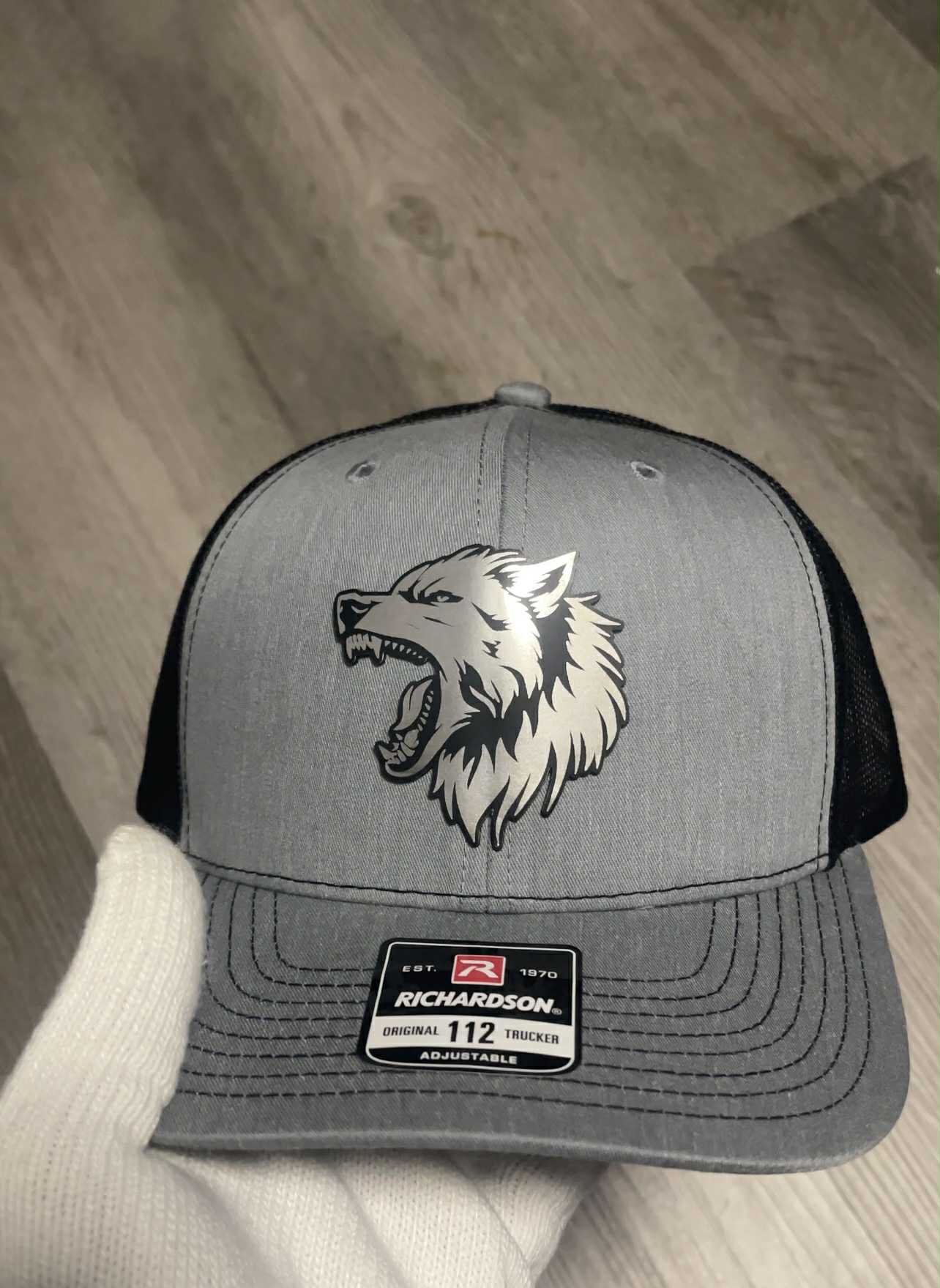Gray and black cap with a wolf logo on a wooden floor