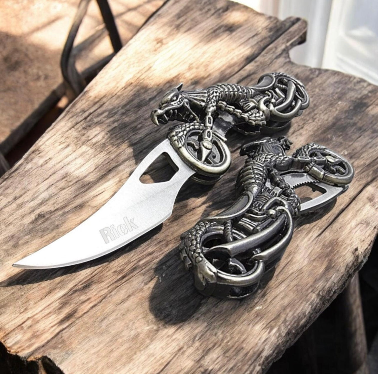 Silver knife with dragon design on a wooden surface