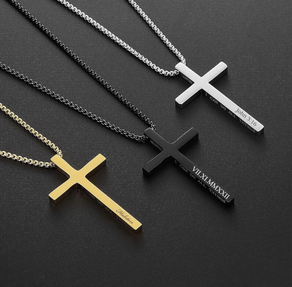 Four cross-shaped necklaces in gold, silver, black, and another color on a dark background.