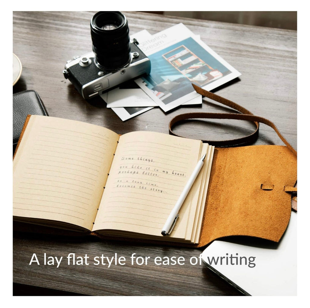 Open notebook with pen, camera, and photos on a wooden surface