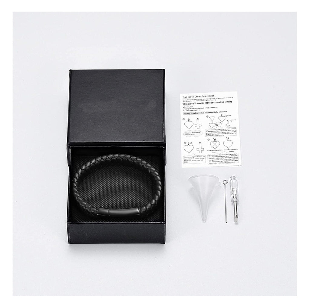 Black bracelet in a box with a funnel, syringe, and paper on a white background