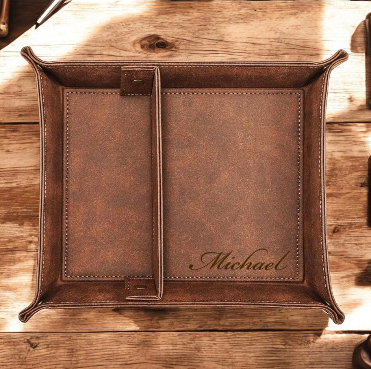 Brown leather tray with 'Michael' engraving on a wooden surface