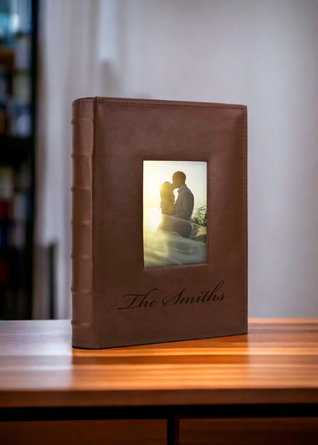 Brown leather photo album with 'The Smiths' on a wooden surface