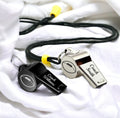 Two whistles with 'Coach Smith' and 'Coach Williams' engraved on them, attached to black lanyards.