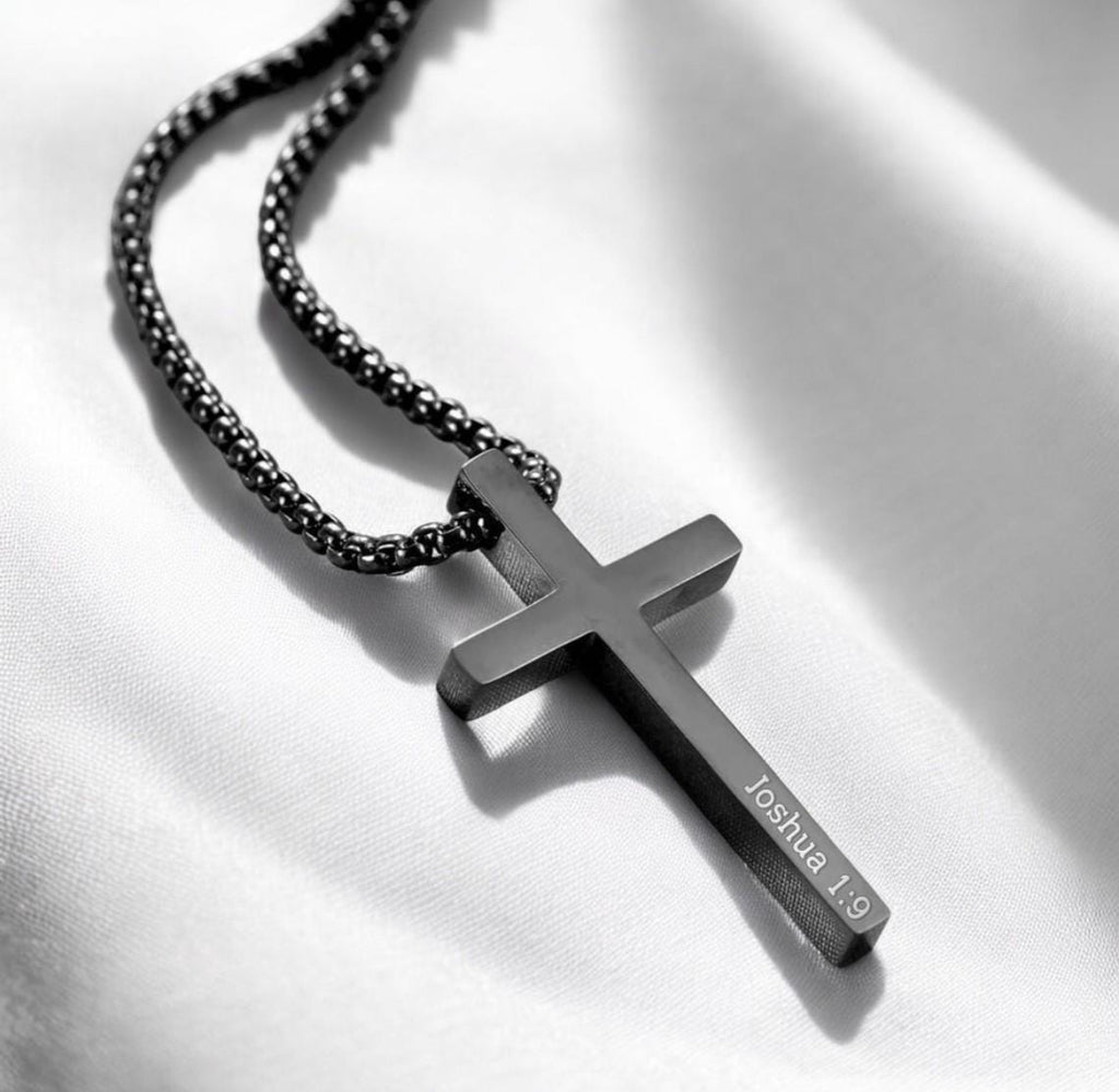 Black cross pendant necklace on a white background