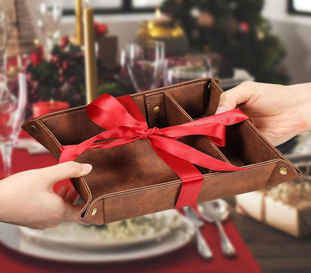 Brown leather wallet with a red ribbon held by hands against a festive background